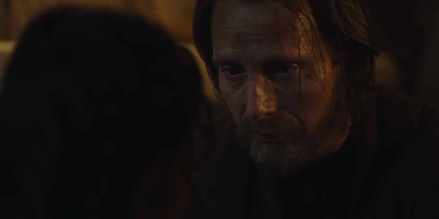 Two men having an intense conversation in dim lighting.